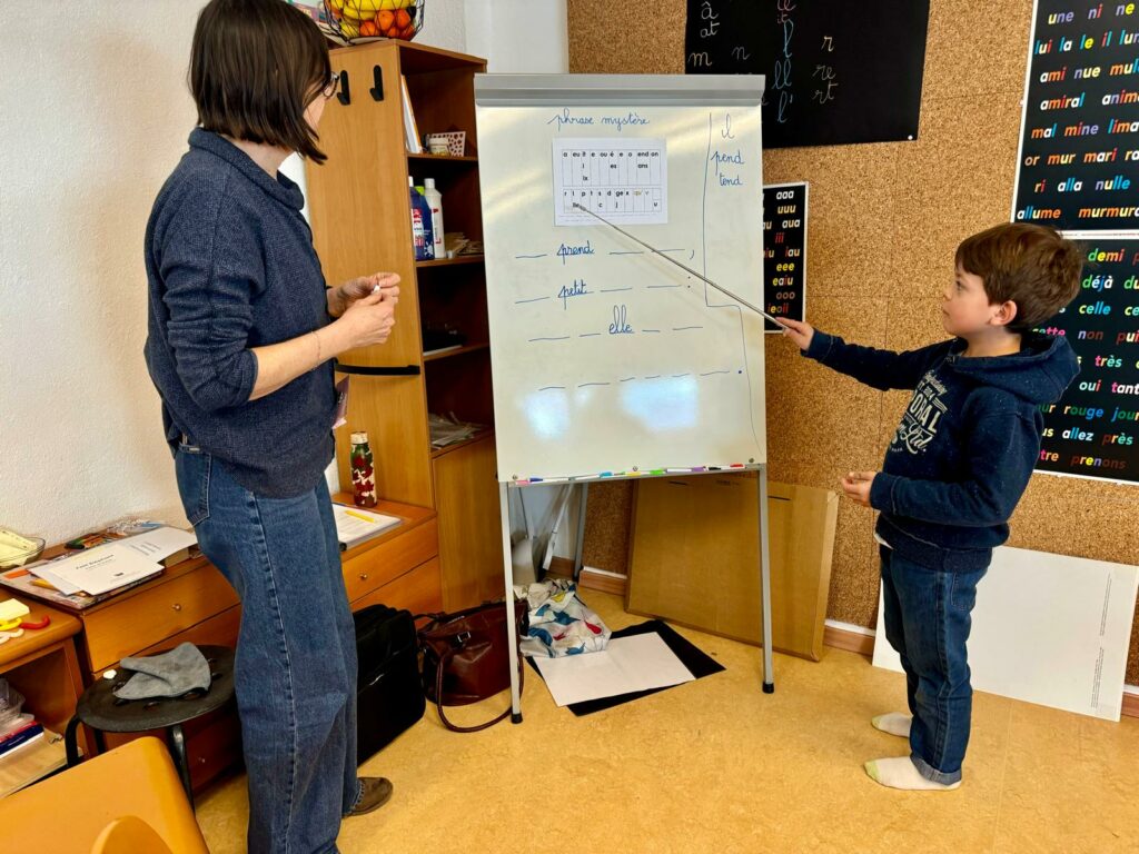 Enseignant avec enfant au tableau